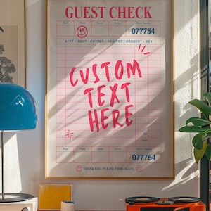 May include: A framed guest check with pink grid lines and text. The words "GUEST CHECK" and "CUSTOM TEXT HERE" are in pink. The check includes fields for date, table, guests, server, and check number. The check number is 077754.