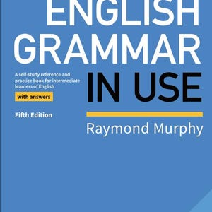 Peut inclure: Un livre bleu intitulé "English Grammar in Use" de Raymond Murphy. La couverture présente un grand texte blanc et une ligne horizontale jaune. C'est une référence d'auto-apprentissage pour les apprenants d'anglais intermédiaires.