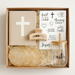 May include: A gift box containing a beige Bible with a white cross, a beige hair clip, a glass tumbler with "Faith" printed on it, stickers, and decorative coasters. The box is filled with shredded paper.