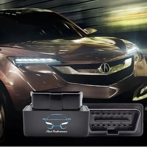 May include: Black OBD2 diagnostic tool with the text "Fleet Performance" and a car graphic. The tool is shown in front of a brown car with bright headlights.