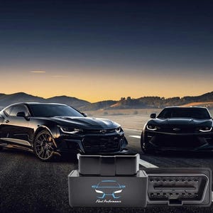 May include: Two black sports cars are parked on a road with a sunset backdrop. In the foreground, a black OBD2 scanner with the text "Fleet Performance" and a car graphic is displayed.