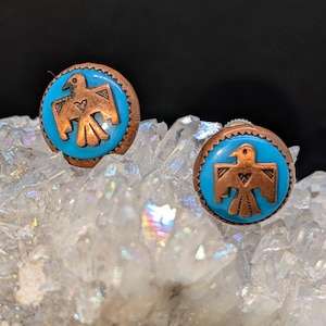 May include: A white ceramic mug with a black handle and the text "But First, Coffee" in a black, bold font. The mug is on a white surface.