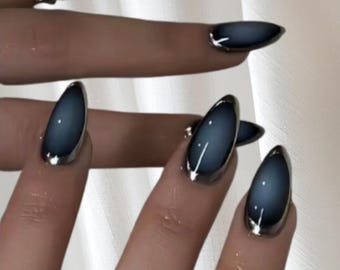 Könnte beinhalten: Ovale, dunkelblaue Nageldesign mit silbernem Metallrand. Die Nägel haben ein glänzendes Finish und sind auf mehreren Fingern zu sehen. Silberringe sind ebenfalls sichtbar.