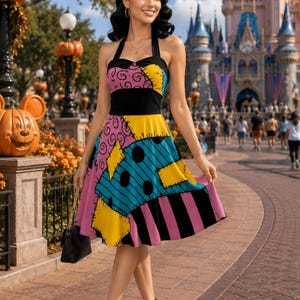 May include: A sleeveless knee-length dress featuring a patchwork pattern of pink, blue, and yellow fabric panels with black polka dots and stripes. The dress has a black bodice with a halter neckline and a flared skirt, paired with black high heels.