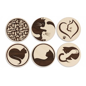 Peut inclure: Ensemble de six dessous de verre en bois avec des motifs de chats. Chaque dessous de verre rond présente une illustration différente de chat, avec des silhouettes, des motifs et un cœur. Les dessous de verre sont en bois clair avec des images de chats marron foncé.