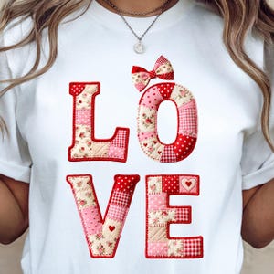 Peut inclure: T-shirt blanc avec le mot "LOVE" en lettres patchwork. Les lettres sont rouges, roses et à motifs floraux, avec un nœud au-dessus du "O". Le design comprend des cœurs.
