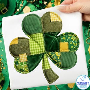 Może przedstawiać: Patchworkowy wzór koniczyny w odcieniach zieleni i żółci, z różnymi fakturami tkanin, takimi jak sztruks, krata vichy i aksamit. Wzór znajduje się na białym tle, z logo Serenity Design w prawym dolnym rogu.