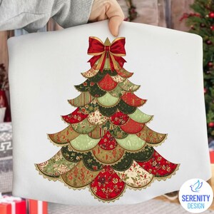 May include: A white pillow featuring a Christmas tree design. The tree is composed of layered, scalloped shapes in red, green, and gold floral patterns, topped with a red bow. The pillow has a gold lace trim.