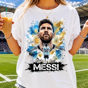 May include: A white t-shirt featuring a graphic print of Lionel Messi. The design includes a large portrait of Messi, a smaller figure of him in a number 10 jersey, the Argentina flag, the AFA crest, and the text MESSI in bold black letters.