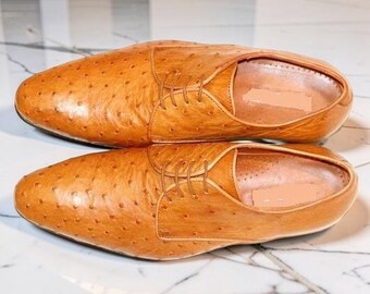 Handgemaakte herenschoenen van leer met struisvogelstructuur en vetersluiting.