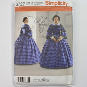 May include: A Simplicity sewing pattern envelope 3727 for a blue and black plaid dress with a white collar and tiered sleeves. The envelope displays two views of the dress, size U5 16, 18, 20, 22, 24, and includes handwritten text.