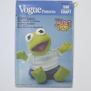 May include: A vintage Vogue Patterns craft pattern featuring Jim Henson's Muppet Babies. The cover shows a plush Baby Kermit wearing a striped shirt and blue shorts. The pattern number is 598, and the design is for Baby Kermit and his clothes.