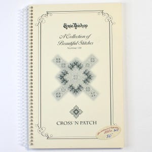 May include: A spiral-bound instructional booklet titled A Collection of Beautiful Stitches Number 139 by Emie Bishop. The cream-colored cover features a black and white cross-stitch pattern, the text CROSS 'N PATCH, and a small oval sticker.