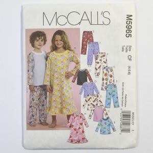 May include: McCall's M5965 sewing pattern envelope for children's pajamas in size CF (4-5-6). The front displays illustrations of various pajama sets, including long-sleeved tops and pants with diverse prints like hearts, soccer balls, and cupcakes.