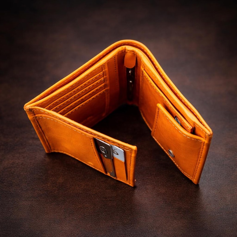 Puede incluir: Cartera de cuero naranja abierta con m&uacute;ltiples ranuras para tarjetas, un compartimento para billetes y un peque&ntilde;o bolsillo para monedas. La cartera est&aacute; hecha de cuero liso y tiene un dise&ntilde;o cl&aacute;sico. La cartera est&aacute; abierta, mostrando su interior.