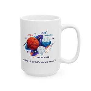 May include: White ceramic mug featuring a colorful graphic of Mars, Europa, and Enceladus, with the text "In Search of Life as we know it." The design includes blue, orange, and white planets and stars. The mug has a large handle.