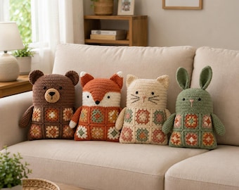 Op de afbeelding: Vier handgemaakte gehaakte knuffels in de vorm van een beer, een vos, een kat en een konijn. Elk dier heeft een effen gekleurd hoofd en armen met een lichaam opgebouwd uit veelkleurige granny squares in tinten oranje, groen en crème.