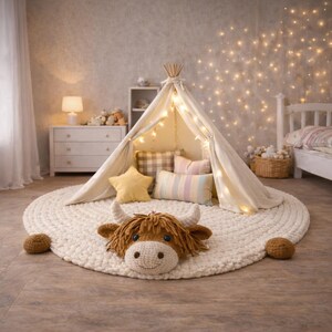 May include: A cozy children's play area featuring a cream-colored teepee tent adorned with string lights, set on a large, round, off-white rug. Decorative pillows in various patterns and a star-shaped pillow add to the inviting atmosphere. A plush Highland cow head rests on the rug.