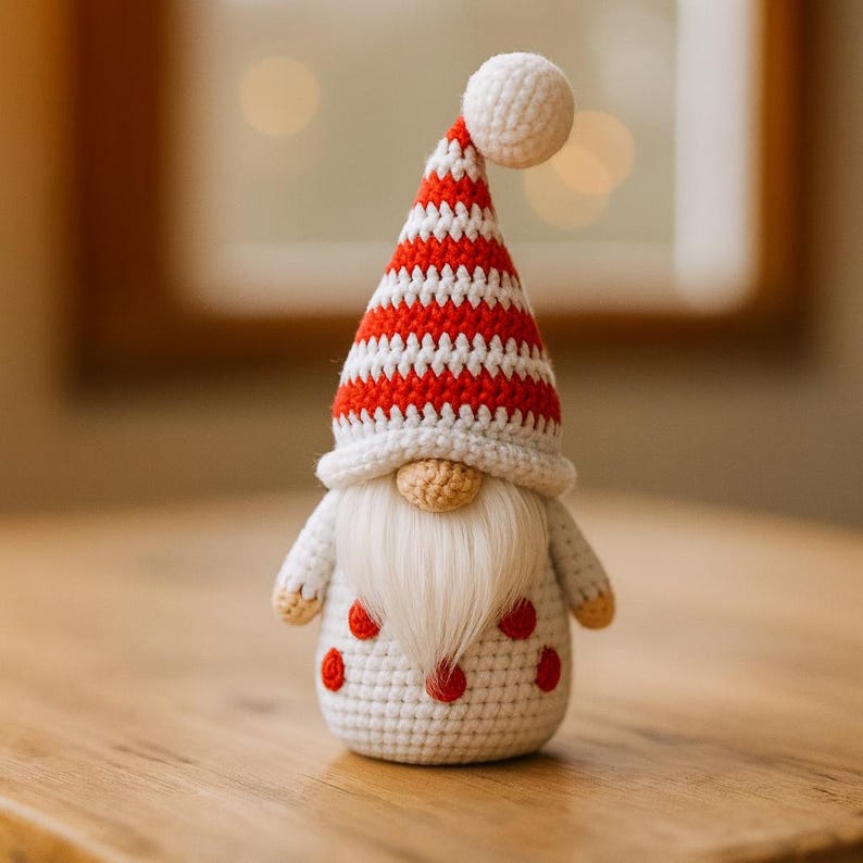 May include: A handmade crochet gnome doll with a white beard and a red and white striped hat. The gnome has a white body with red polka dots. The doll is a festive decoration.