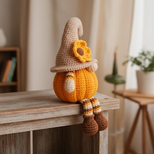 May include: A handmade crochet pumpkin gnome with a tan hat, sunflower accent, and striped legs. The pumpkin body is orange, and the legs are brown and tan. This fall-themed decoration is perfect for autumn.