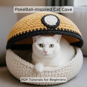 May include: A white cat in a crocheted cat cave. The cat cave is designed to look like a Pokeball, with a yellow top, black trim, and a white and black circle. The text "PokéBall-Inspired Cat Cave" and "PDF Tutorials for Beginners" are visible.