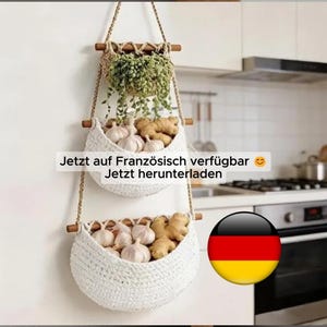 May include: A three-tiered hanging basket made of white woven material, suspended by rope. The top basket holds a green plant, while the lower baskets contain garlic and ginger. The image includes text in German.