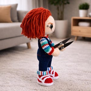 May include: Crocheted doll with red hair, blue overalls, and striped sleeves. The doll is holding black scissors and wearing red and white sneakers. The doll's face is detailed with stitched features.
