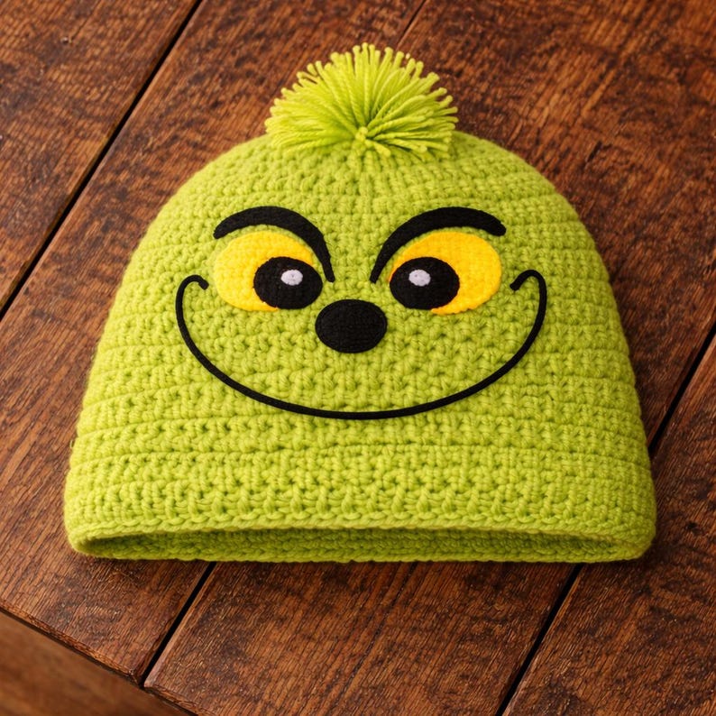 Peut inclure: Un bonnet vert crochet&eacute; repr&eacute;sentant le visage du Grinch. Le chapeau a des yeux jaunes, un nez et une bouche noirs, et un pompon vert sur le dessus. Le chapeau est fait d'un fil doux et textur&eacute; et est con&ccedil;u pour s'adapter parfaitement &agrave; la t&ecirc;te.