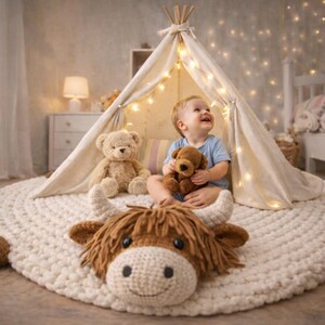 May include: A child sits inside a small teepee tent, surrounded by soft toys and a large, crocheted cow rug. The rug is cream-colored with a brown cow head. A teddy bear and a puppy plushie are also present.