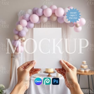 May include: A blank white card held between two hands, with a blurred background featuring a balloon arch in shades of pink and beige. The word "MOCKUP" is overlaid on the image. Icons for Canva, Procreate, and Photoshop are visible.