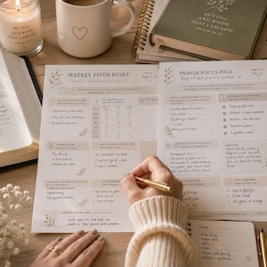 May include: A printed weekly faith reset and prayer focus planner sheet with sections for goals, prayer requests, and scripture. The paper features floral accents and text including Weekly Faith Reset and Prayer Focus Page, alongside a gold pen.