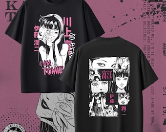 May include: Black t-shirts with manga-style illustrations. One shirt features a woman with the text "I AM TOMIE" and Japanese characters. The other shirt displays multiple manga panels. Halloween-themed.