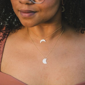 Model is wearing design A and Design E in 14 karat yellow gold filled. Each design is unique, just like our best friends. Hand hammered and handcrafted, these beautiful moons are made from elevated materials and meant to last for years to come.