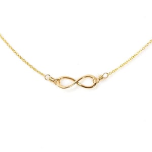 May include: A gold infinity symbol necklace with a delicate chain.