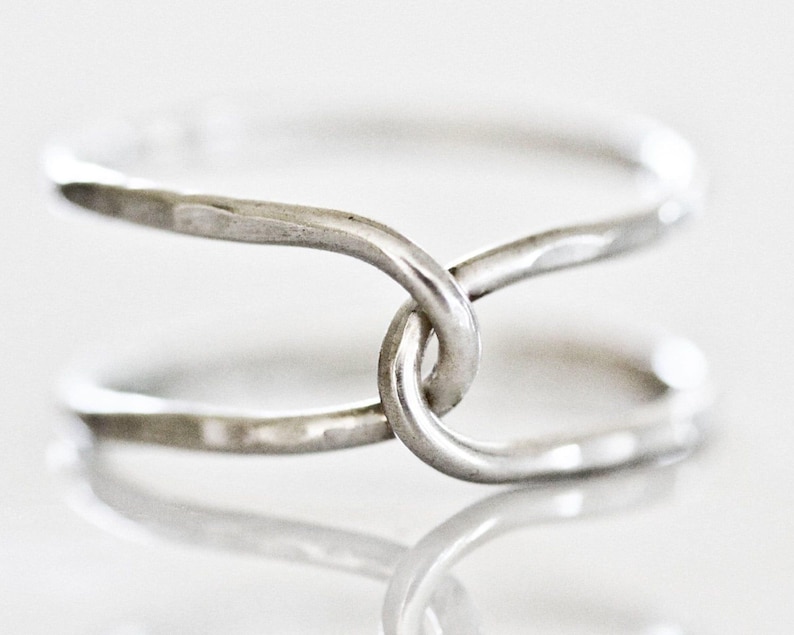 A silver ring with two intertwined rings forming a unique and intricate design.