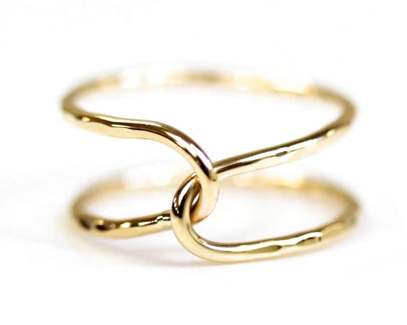 A close-up image of two gold rings with a twisted, intertwined design.