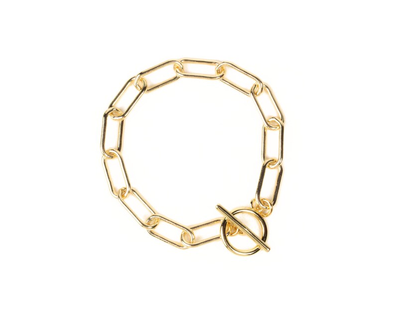 Puede incluir: Un brazalete de cadena dorada con cierre de palanca.