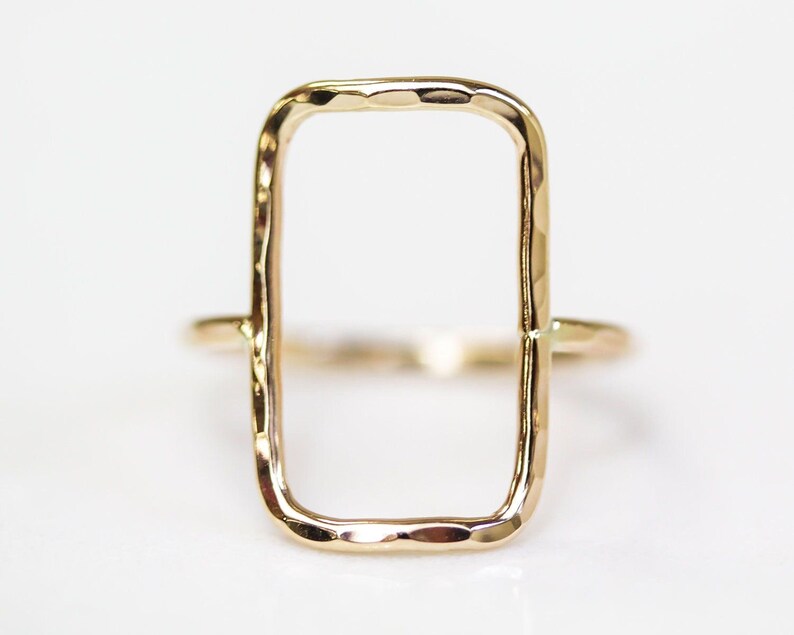A simple, rectangular-shaped gold ring with a smooth, shiny finish.