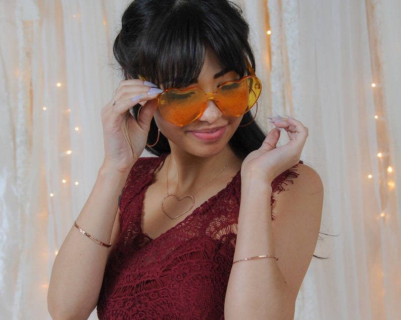 Image shows model wearing a few of our ultra thin 14 karat rose gold filled bangles. Each bangle bracelet is handcrafted from 14 karat Rose Gold Filled. Adding rose gold bangles to any ensemble or stacking bracelet set offers a treat for the senses.