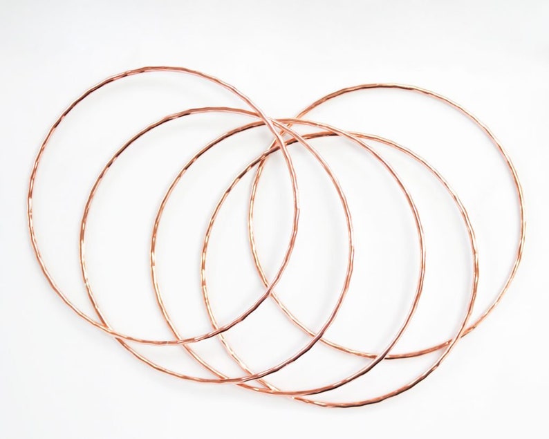Image shows five of our 14 karat rose gold filled bangles. A hand hammered texture gives them their special sparkle. Made our of high quality rose gold filled material to stand the test of time. Can be worn for years without turning or tarnishing