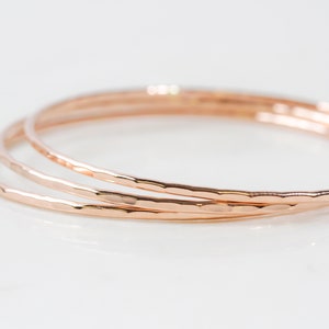 Each fine metal bangle bracelet is handcrafted from 14 karat Rose Gold Filled. This exquisite material is nickel free and perfect for sensitive skin. A hand hammered texture gives them their special sparkle. Grab one or several to stack. Great gifts.