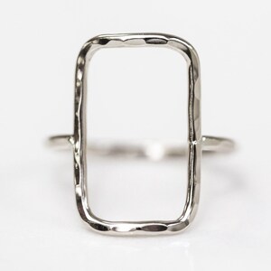 A simple silver ring with a rectangular cutout in the center.