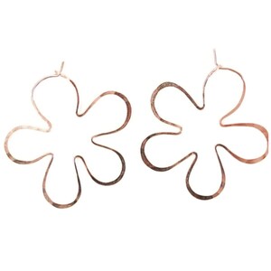 May include: A pair of rose gold flower-shaped hoop earrings. The earrings are made of thin metal and have a delicate, feminine look.