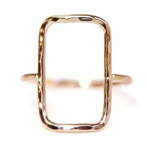 A simple, rectangular-shaped gold ring with a smooth, shiny finish.