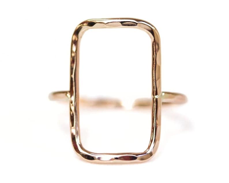A simple, rectangular-shaped gold ring with a smooth, shiny finish.