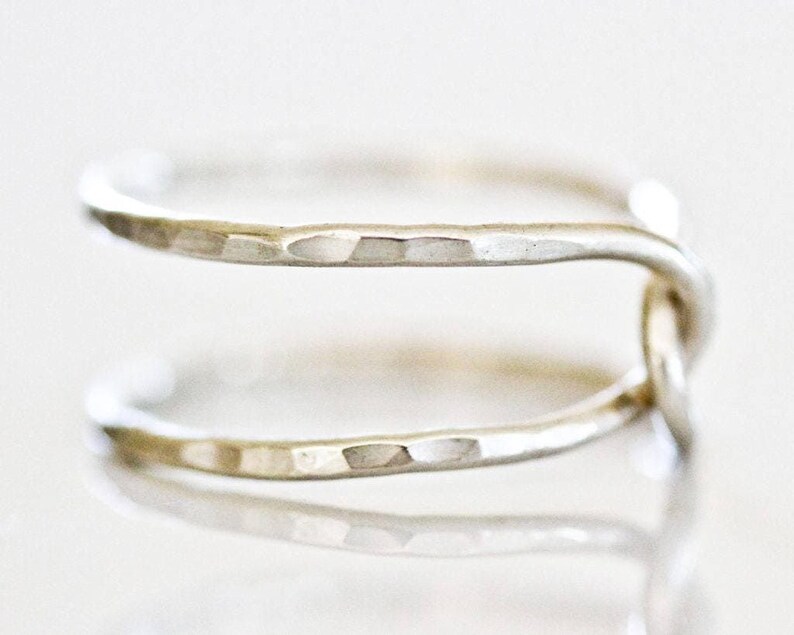 A close-up image of a silver ring with a twisted design.