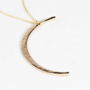 The Mystic Moon Necklace elevates celestial jewelry and beams with handcrafted quality.
Each moon pendant is hand forged by our team of women artists. The crescent moon is hand hammered with texture that mimics the look of the moon and measures 44mm