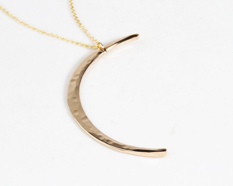 The Mystic Moon Necklace elevates celestial jewelry and beams with handcrafted quality.
Each moon pendant is hand forged by our team of women artists. The crescent moon is hand hammered with texture that mimics the look of the moon and measures 44mm