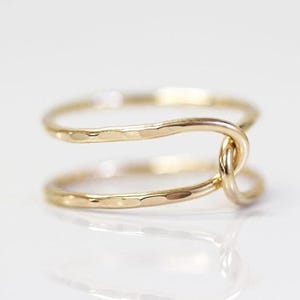 A gold ring with a twisted design, featuring two intertwined rings.
