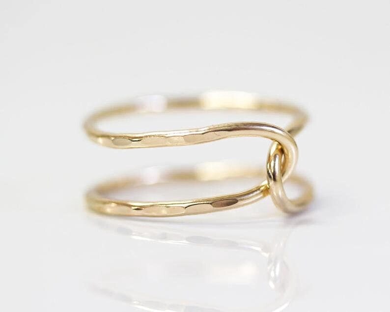 A gold ring with a twisted design, featuring two intertwined rings.